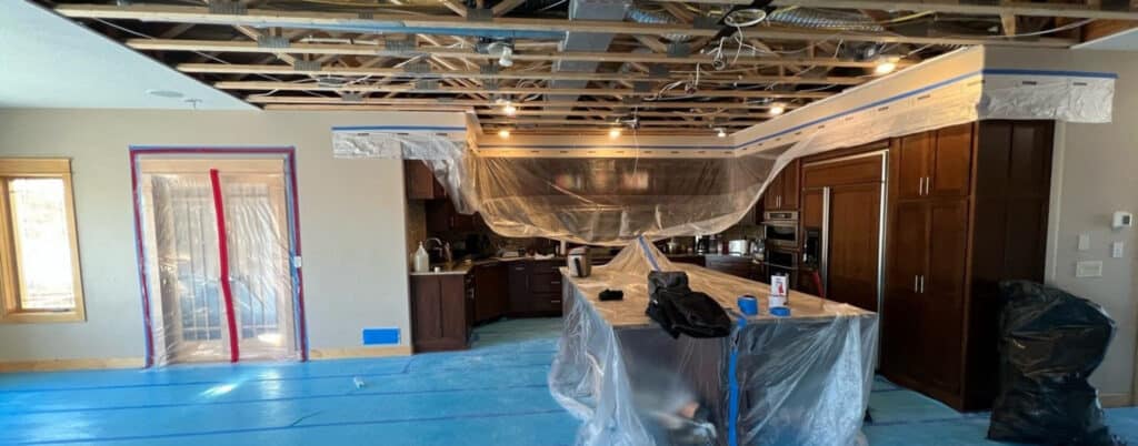Opened ceiling and drying setup in a water-damaged lower level in Eden Prairie, MN, by Kiser Construction